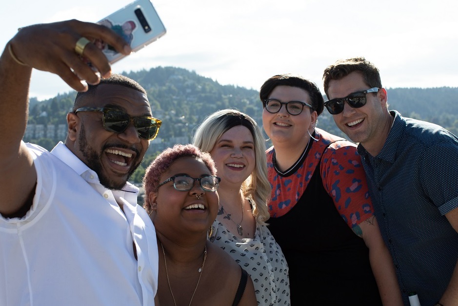 A group of Autistic friends is standing outside taking a selfie.